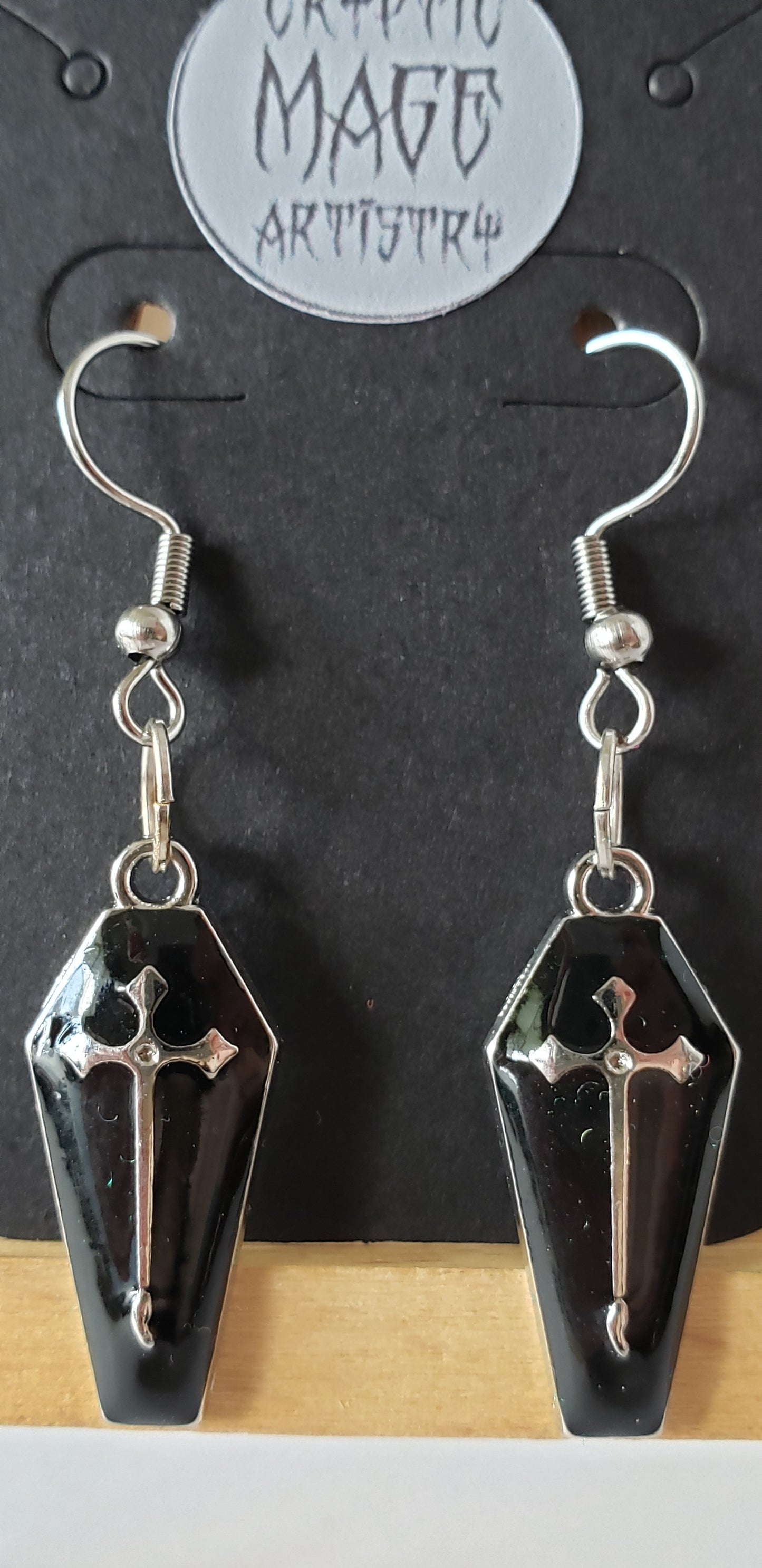 Coffin and cross dangle earrings.